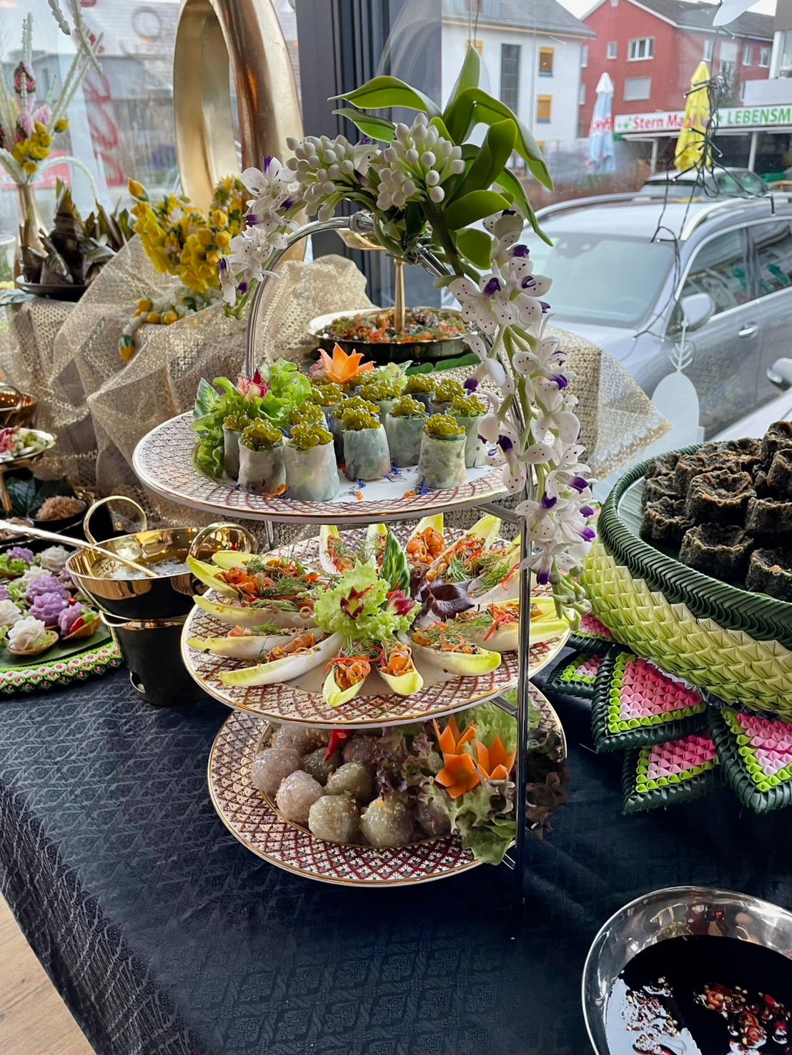 Etagère mit Thai Vorspeisen und Orchideen